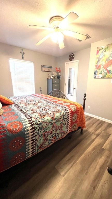 bedroom with baseboards, ceiling fan, a textured ceiling, and wood finished floors