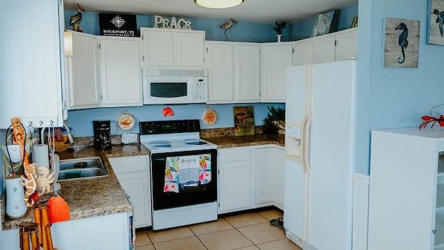 719 E King St, Rockport, TX 78382 - kitchen with white appliances, white cabinetry, light tile patterned floors, and a sink