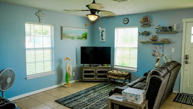 719 E King St, Rockport, TX 78382 - living area featuring healthy amount of natural light, tile patterned floors, a ceiling fan, and baseboards
