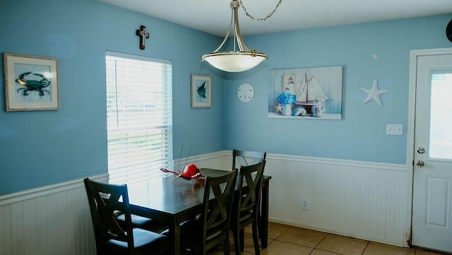 719 E King St, Rockport, TX 78382 - tiled dining room featuring wainscoting, healthy amount of natural light, and wooden walls