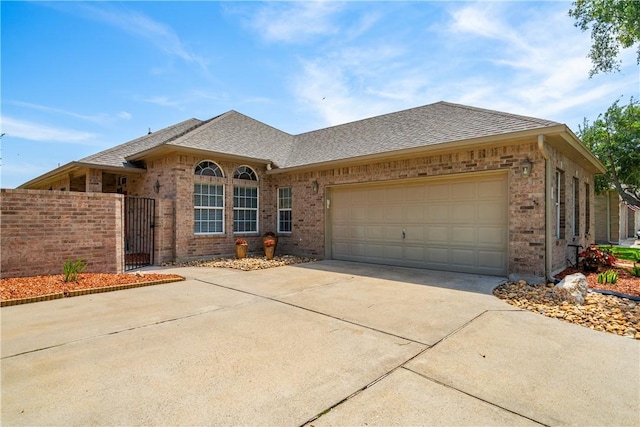 6217 Garden Ct, Corpus Christi, TX 78414 - view of front of house with brick siding, driveway, a garage, a shingled roof, and fence
