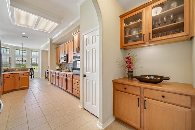6217 Garden Ct, Corpus Christi, TX 78414 - kitchen featuring appliances with stainless steel finishes, light tile patterned floors, ornamental molding, glass insert cabinets, and arched walkways