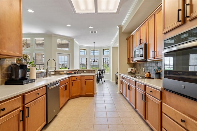 6217 Garden Ct, Corpus Christi, TX 78414 - kitchen featuring appliances with stainless steel finishes, ornamental molding, a sink, a peninsula, and tasteful backsplash
