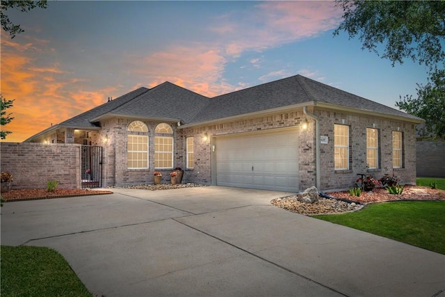 6217 Garden Ct, Corpus Christi, TX 78414 - view of front facade with driveway, brick siding, an attached garage, a shingled roof, and a gate