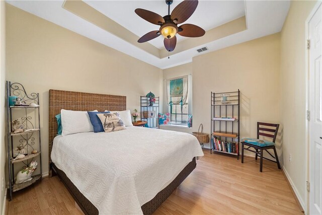 6217 Garden Ct, Corpus Christi, TX 78414 - bedroom with a raised ceiling, light wood-style flooring, a ceiling fan, and baseboards
