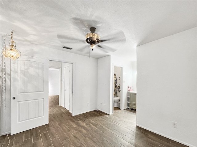 empty room with dark hardwood / wood-style floors, ceiling fan, and a textured ceiling