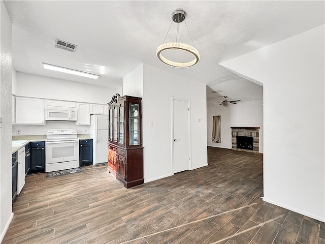 kitchen featuring white cabinets, white appliances, decorative light fixtures, and dark wood-type flooring