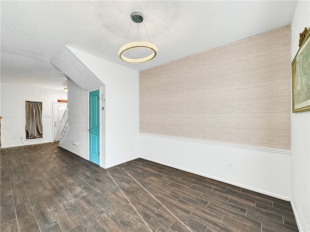 spare room featuring dark hardwood / wood-style flooring and a textured ceiling