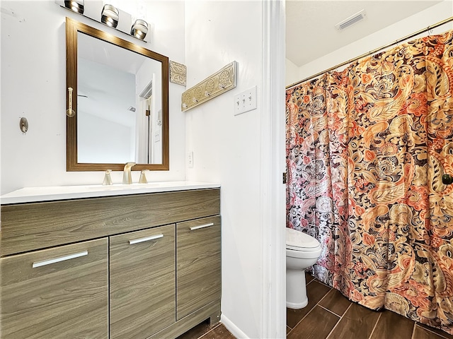 bathroom with vanity, wood-type flooring, and toilet