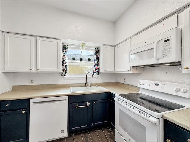 kitchen featuring white appliances, white cabinetry, dark wood-type flooring, and sink