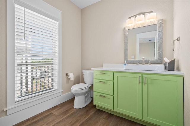 bathroom with toilet, vanity, and hardwood / wood-style flooring