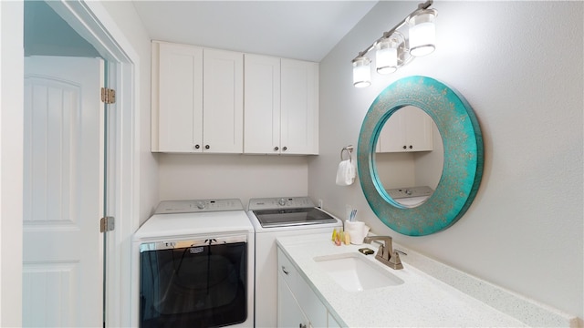 laundry room with independent washer and dryer, cabinet space, and a sink