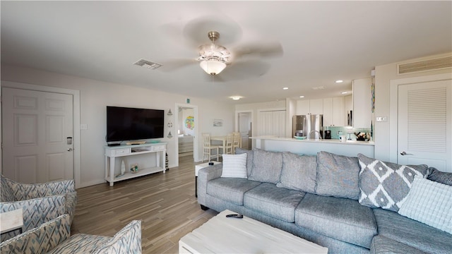 living area with light wood-style flooring, recessed lighting, visible vents, and a ceiling fan