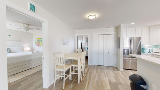 kitchen featuring light countertops, light wood-style flooring, white cabinets, ceiling fan, and stainless steel fridge with ice dispenser