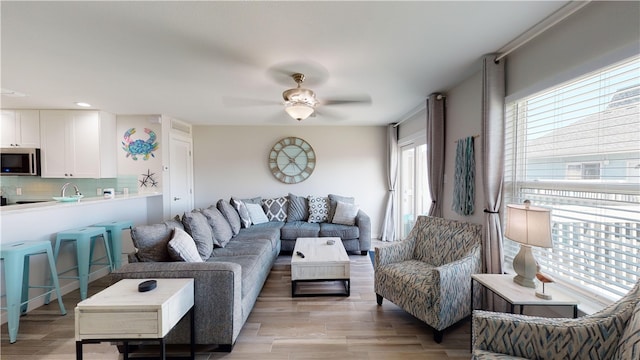 living room with ceiling fan and light wood-style floors