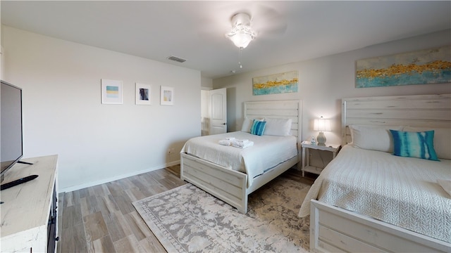 bedroom featuring visible vents, light wood-style flooring, and baseboards