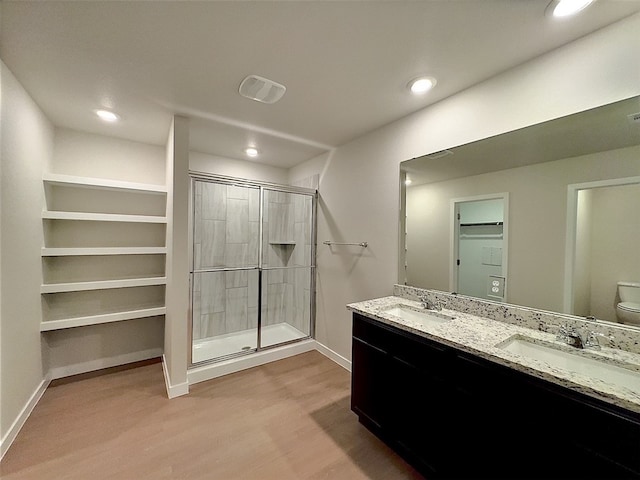 3014 Stone Creek Dr, Corpus Christi, TX 78410 - full bath with wood finished floors, a shower stall, toilet, double vanity, and baseboards