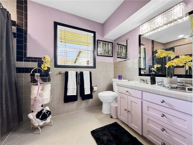 130 Alta Plz, Corpus Christi, TX 78411 - full bathroom with tile walls, tile patterned floors, toilet, vanity, and a wainscoted wall