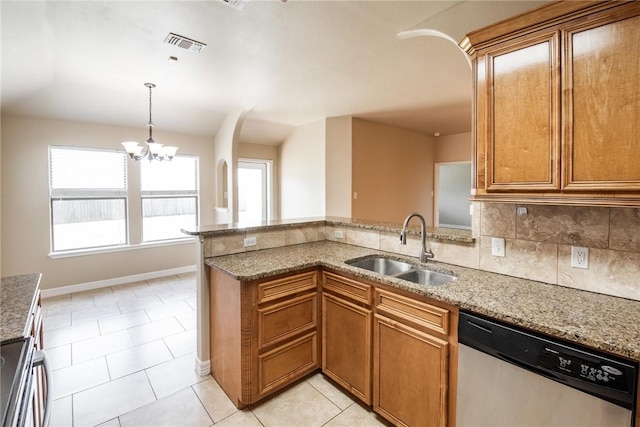 4384 Summer Wind Dr, Corpus Christi, TX 78413 - kitchen featuring appliances with stainless steel finishes, a peninsula, light stone countertops, brown cabinetry, and a chandelier