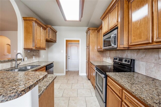 4384 Summer Wind Dr, Corpus Christi, TX 78413 - kitchen featuring appliances with stainless steel finishes, light stone countertops, and brown cabinets