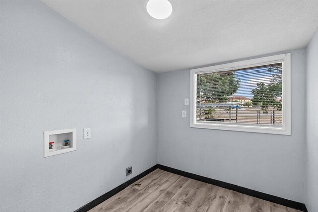 1006 Vernon Dr, Corpus Christi, TX 78407 - laundry area featuring washer hookup, light wood-type flooring, electric dryer hookup, and baseboards