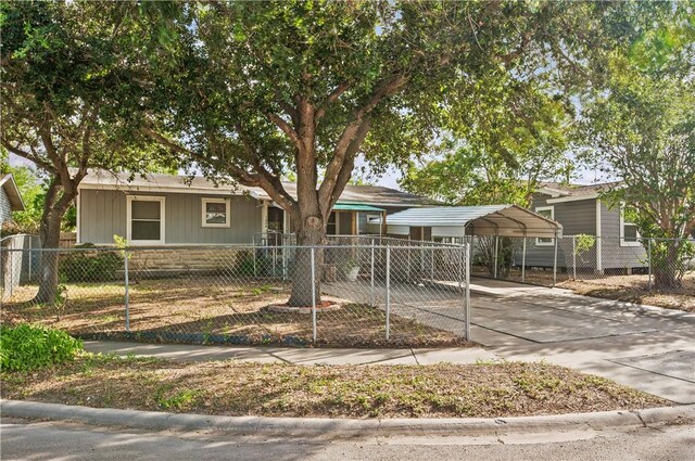 1006 Vernon Dr, Corpus Christi, TX 78407 - single story home with a detached carport, a fenced front yard, stone siding, and driveway