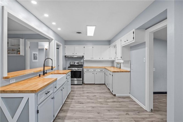 1006 Vernon Dr, Corpus Christi, TX 78407 - kitchen featuring stainless steel gas range oven, butcher block countertops, a sink, under cabinet range hood, and light wood-style flooring