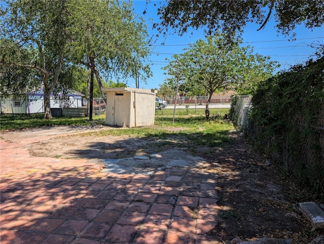 view of patio with a storage unit, an outdoor structure, and fence