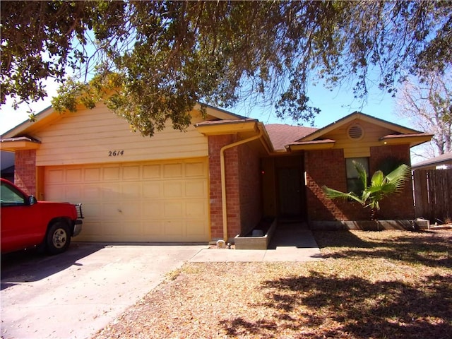 ranch-style house featuring concrete driveway, brick siding, and an attached garage