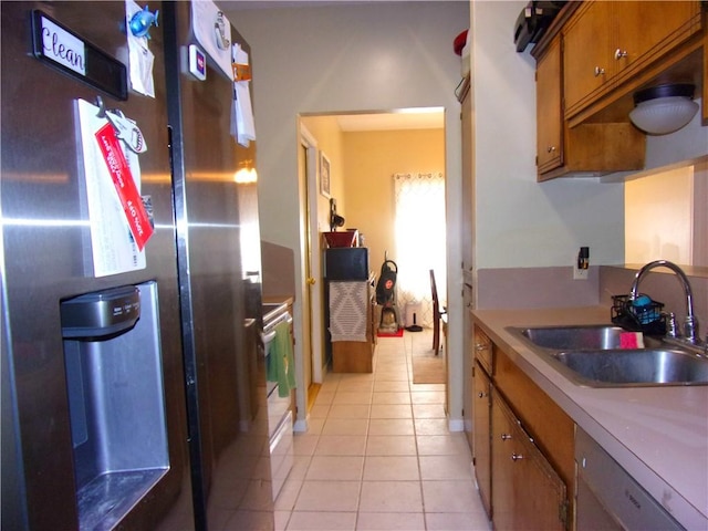 kitchen featuring stainless steel fridge, brown cabinets, white dishwasher, a sink, and light tile patterned flooring