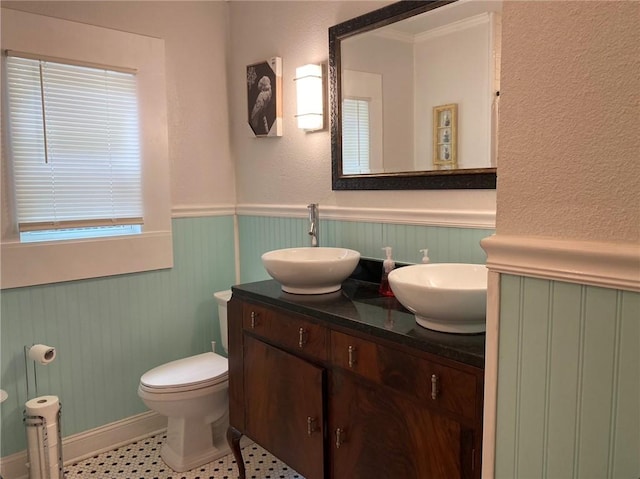 438 Indiana Ave, Corpus Christi, TX 78404 - bathroom with a wainscoted wall, double vanity, toilet, and baseboards