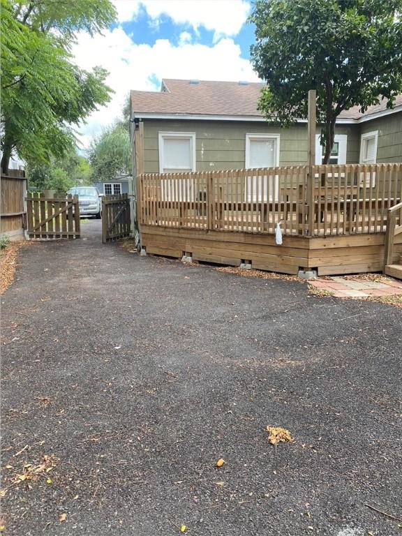 438 Indiana Ave, Corpus Christi, TX 78404 - rear view of property featuring a deck, fence, and a shingled roof