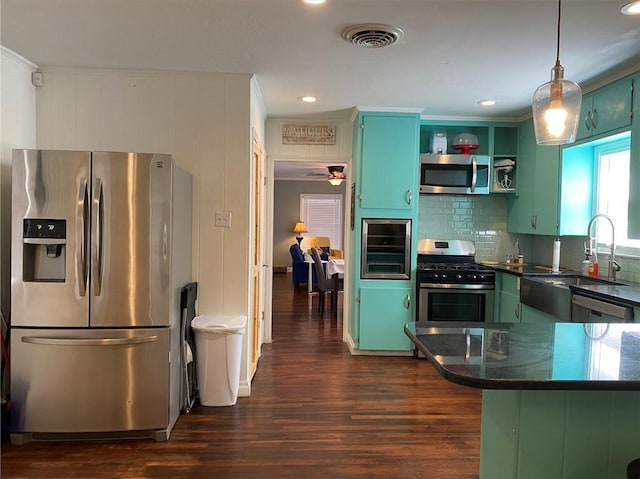 438 Indiana Ave, Corpus Christi, TX 78404 - kitchen featuring stainless steel appliances, green cabinetry, dark wood-type flooring, a sink, and dark countertops
