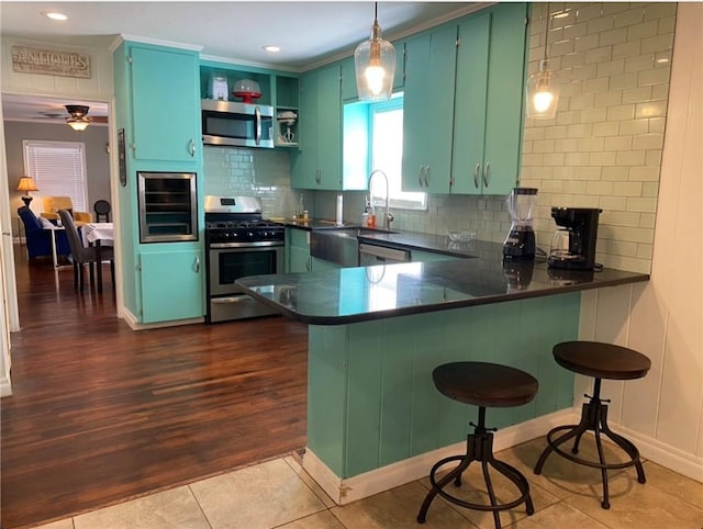 438 Indiana Ave, Corpus Christi, TX 78404 - kitchen featuring stainless steel appliances, dark countertops, a peninsula, tasteful backsplash, and recessed lighting