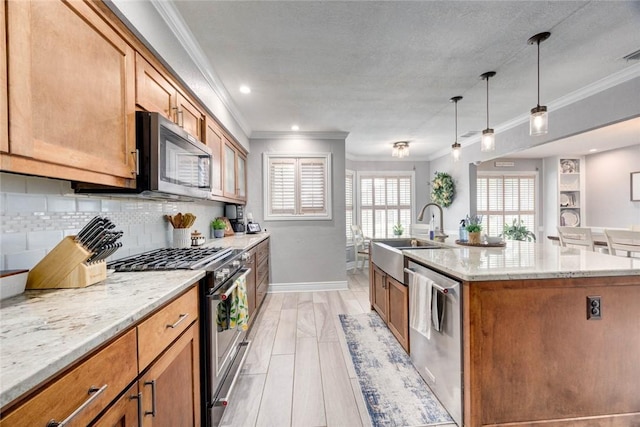 108 Lost Creek Dr, Portland, TX 78374 - kitchen featuring stainless steel appliances, a sink, ornamental molding, baseboards, and a kitchen island with sink