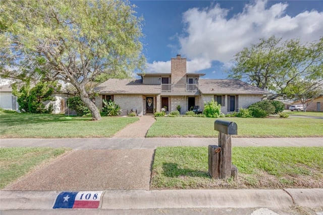 108 Lost Creek Dr, Portland, TX 78374 - view of front facade featuring a balcony, a front yard, a chimney, and brick siding