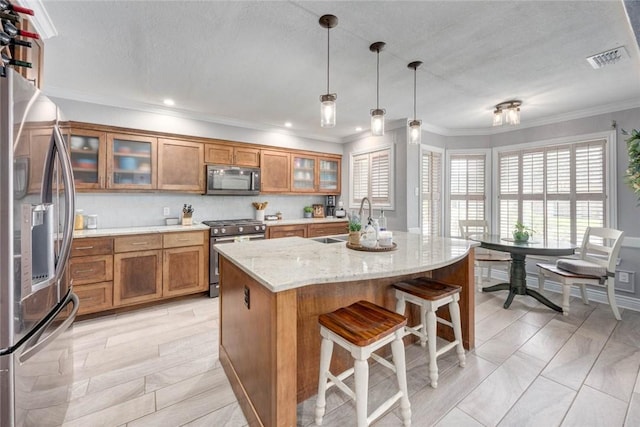 108 Lost Creek Dr, Portland, TX 78374 - kitchen with appliances with stainless steel finishes, brown cabinetry, ornamental molding, healthy amount of natural light, and a sink