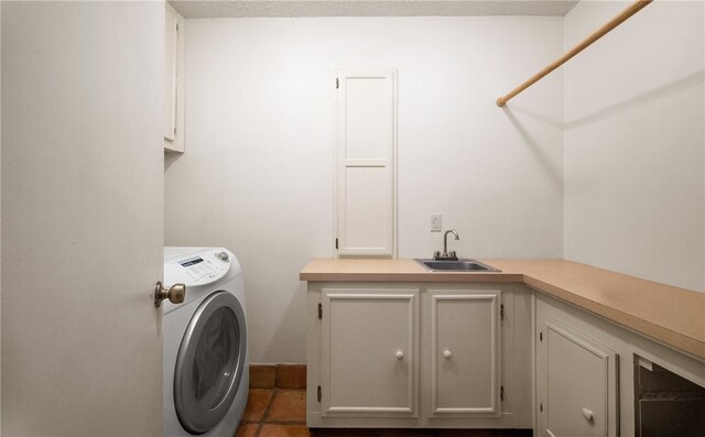 clothes washing area featuring cabinets, dark tile patterned floors, sink, and washer and dryer