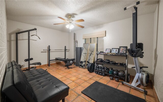 exercise area with ceiling fan, a textured ceiling, and light tile patterned floors