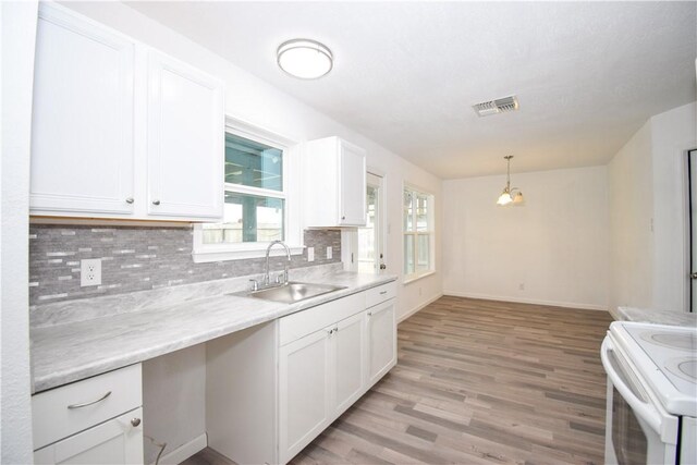 kitchen featuring sink, white cabinetry, hanging light fixtures, tasteful backsplash, and white electric stove