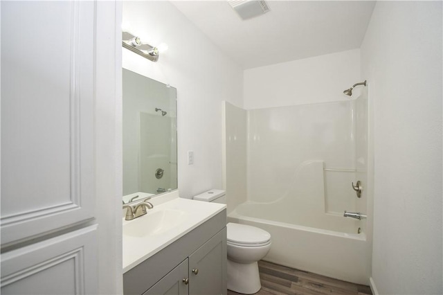 full bathroom featuring hardwood / wood-style flooring,  shower combination, toilet, and vanity