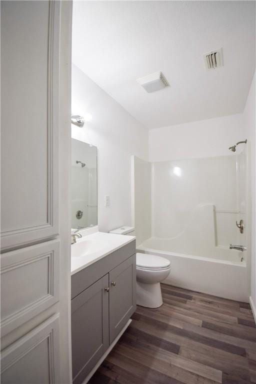 full bathroom with hardwood / wood-style flooring, vanity, toilet, and bathtub / shower combination