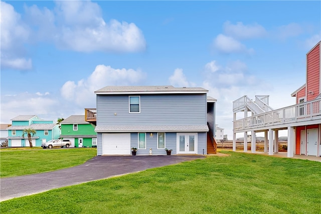 back of house with a garage, a wooden deck, and a yard