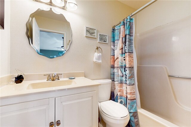 full bathroom with vanity, shower / bath combination with curtain, and toilet