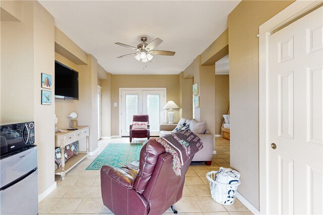 tiled living room with french doors and ceiling fan