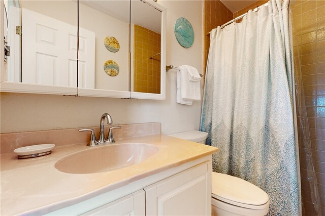 bathroom with a shower with shower curtain, vanity, and toilet