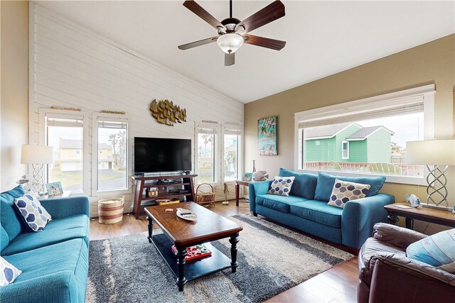 living room with hardwood / wood-style floors, vaulted ceiling, and ceiling fan