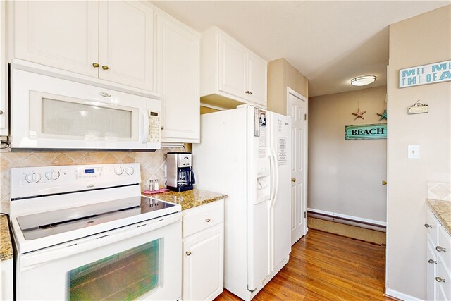 kitchen featuring white appliances, light stone countertops, and white cabinetry