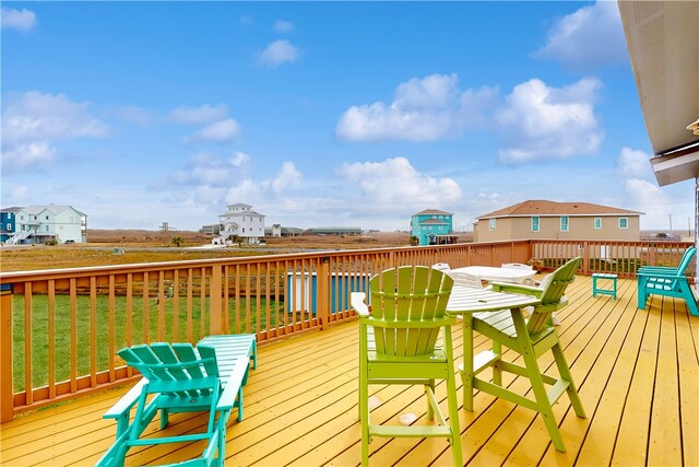 wooden deck featuring a lawn