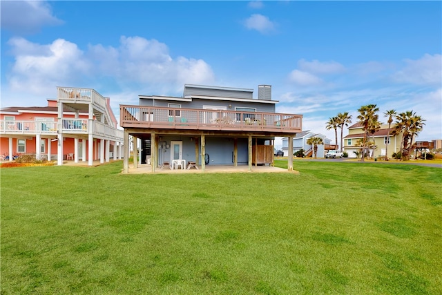 back of house featuring a lawn, a patio area, and a deck